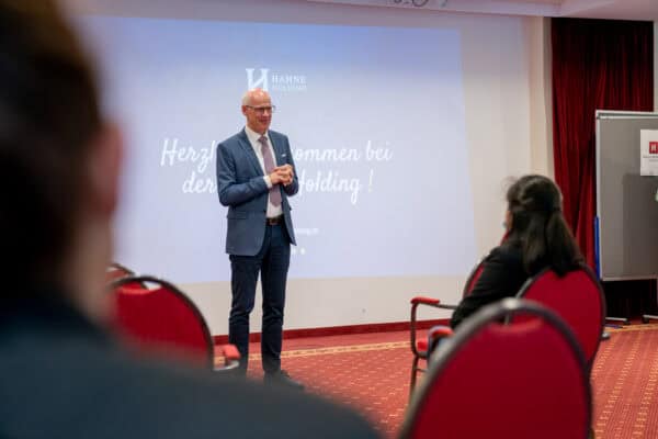Hahne Holding Präsentation auf einer Veranstaltung mit Firmenlogo im Hintergrund.