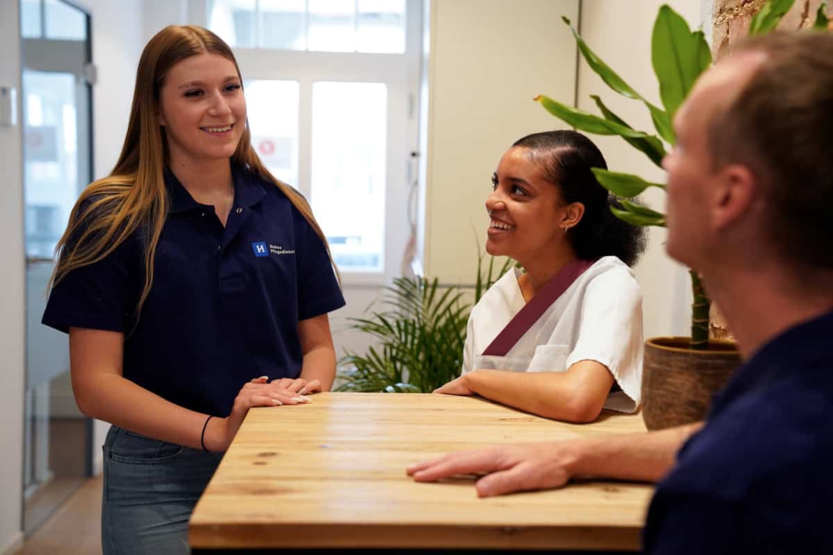 Engagiertes Pflegepersonal im Gespräch, freundliche Betreuung im Hahne Holding Pflegebereich.