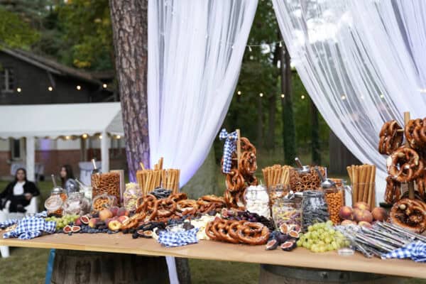 Verführerischer Süßigkeiten- und Brezenschwein mit Früchten auf ausgedecktem Buffet, outdoor, für Events und Feiern.