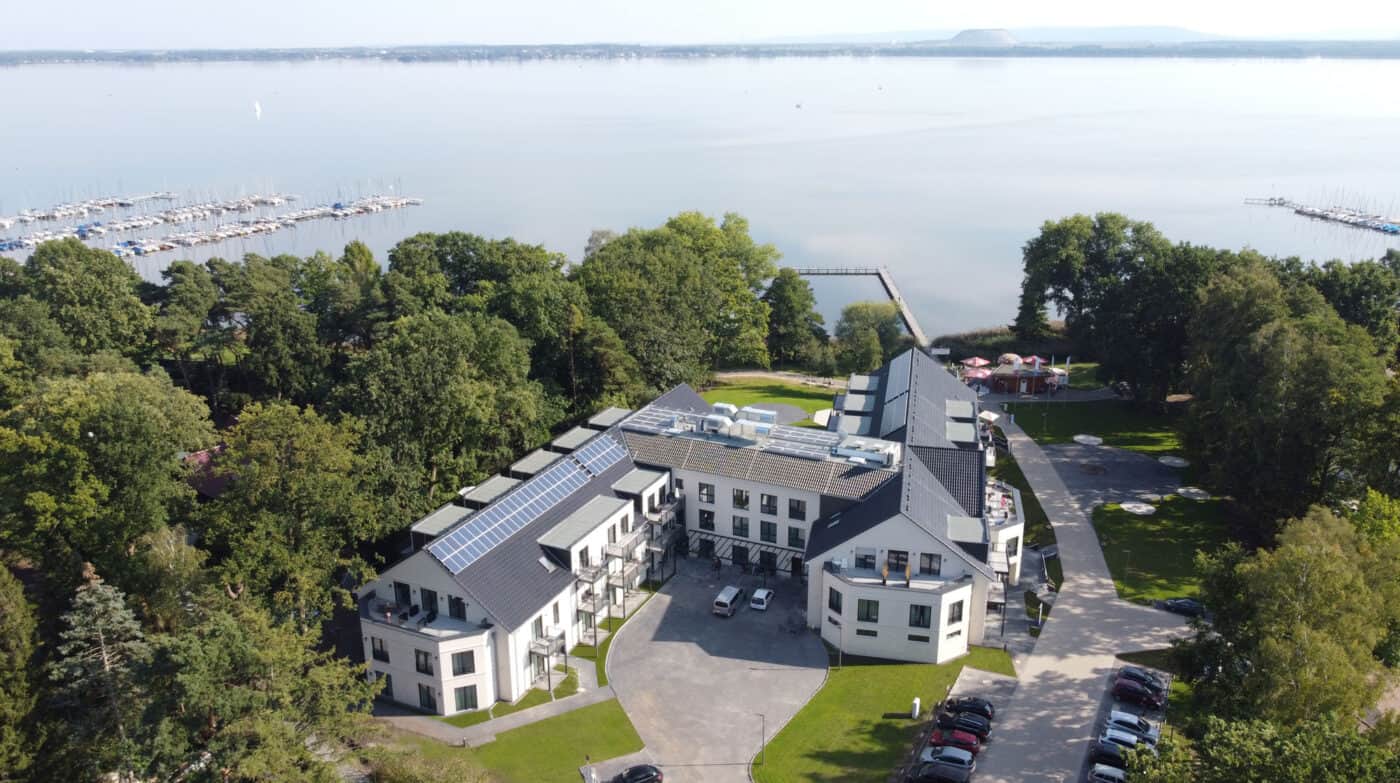 Modernes Gebäude mit Solaranlagen am Wasser in Hahne Holding, nachhaltige Unternehmenszentrale in Deutschland.