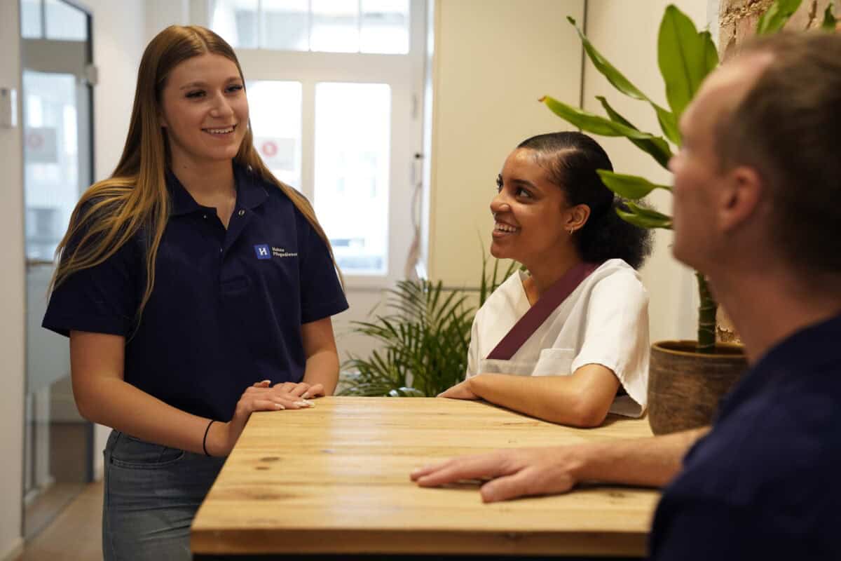 Hahne Holding: Pflegepersonal im Gespräch mit Patienten in freundlicher Atmosphäre.