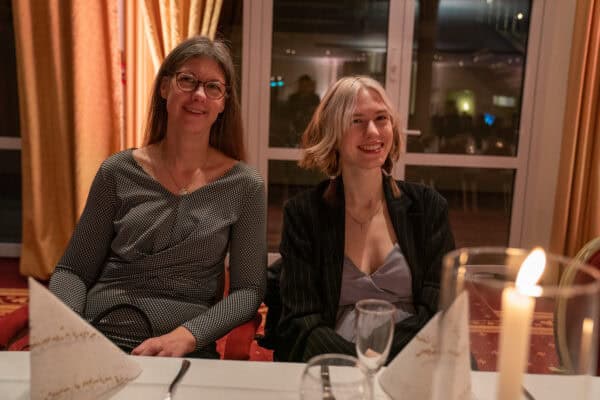 Elegante Damen bei festlicher Abendveranstaltung, moderne Business-Mode, höfliches Netzwerken, Hahne Holding Event, festliche Atmosphäre.