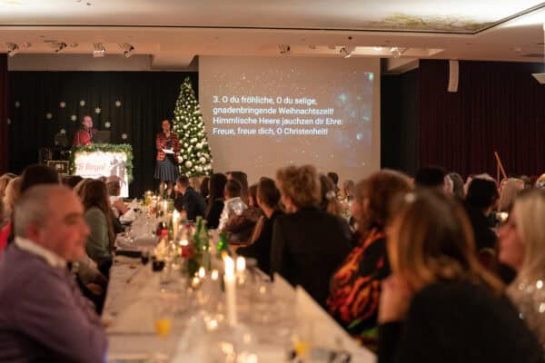 Festliche Weihnachtsveranstaltung bei Hahne Holding mit Publikum und Weihnachtsdekoration.