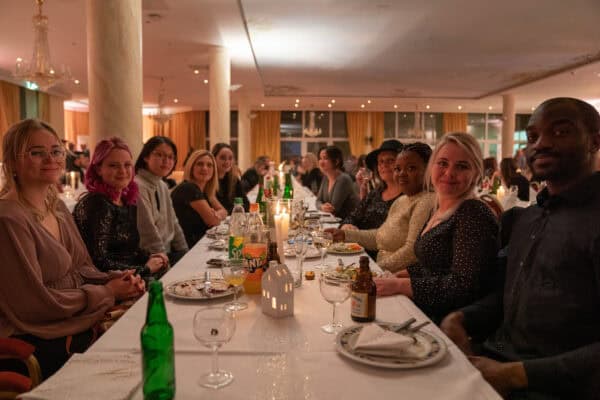 Fröhliche Gruppe beim festlichen Dinner in elegantem Ambiente, als Teil der Hahne Holding Veranstaltungen.