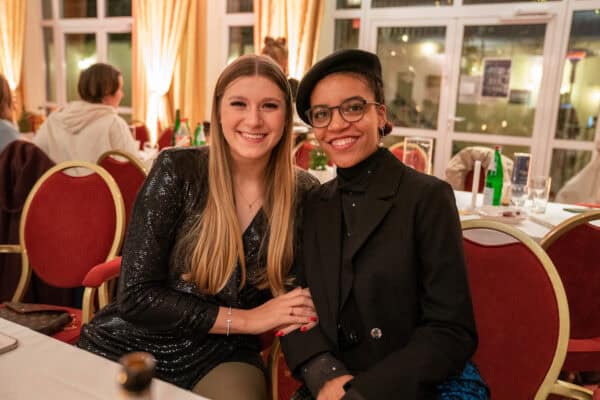 Elegante Frauen bei festlicher Veranstaltung im Restaurant, gemütliche Atmosphäre, soziale Interaktion, festliches Ambiente.