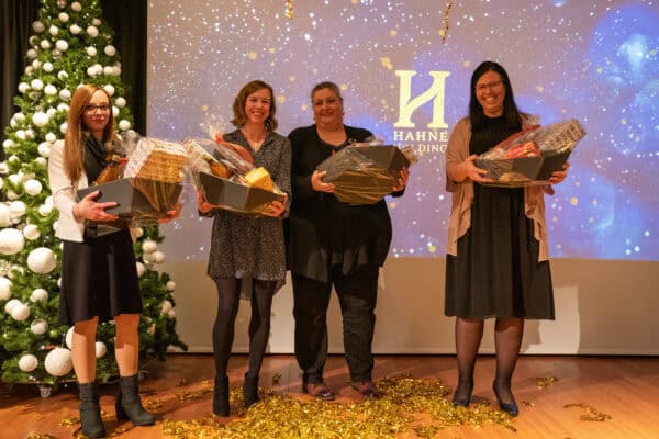 Festliche Mitarbeiterehrung bei Hahne Holding, Team mit Geschenken während Weihnachtsfeier.