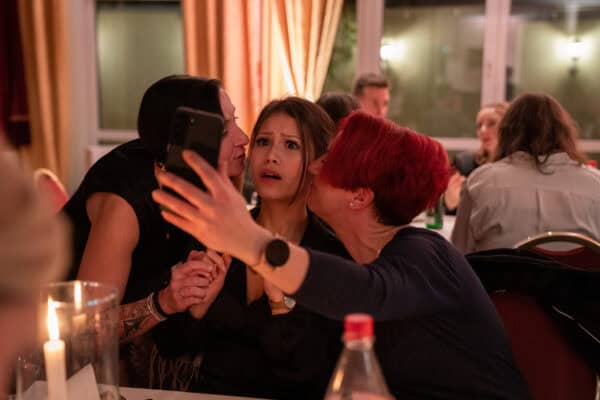 Aufnahmen von Frauen in geselliger Runde bei einer Feier, Lachen und Gespräche, freundliche Atmosphäre.