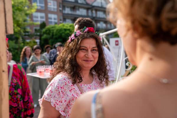 Freundin beim Festivalevent, Networking, Feiern, Gemeinschaft in urbaner Umgebung, fröhliches Treffen, spontane Gespräche.