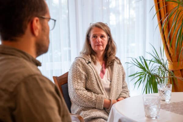 議 alt text: Geschäftiges Gespräch zwischen zwei Fachleuten bei einem Meeting in einem eleganten Raum.