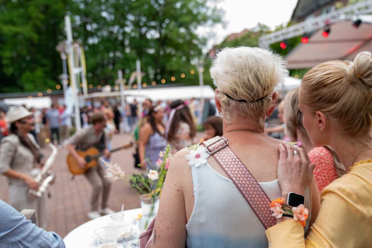 Entzückendes Festival im Freien mit Musik und lachenden Menschen, lebendige Atmosphäre, Menschen beim Feiern.