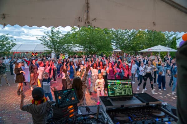 Lebendige Tanzveranstaltung bei Hahne Holding mit Live-DJ im Freien.