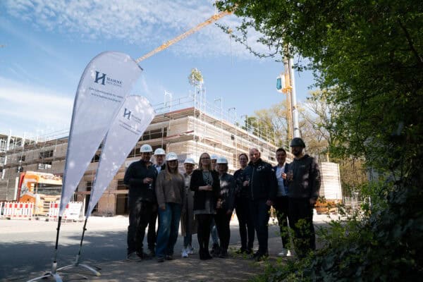 Innovative Bauprojekt von Hahne Holding mit Team vor laufender Baustelle, nachhaltige Bauweise, Dachkonstruktion und Baufortschritt.