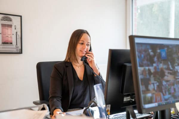 Hahne Holding, professionelle Büroangestellte am Telefon, moderne Unternehmenskommunikation.