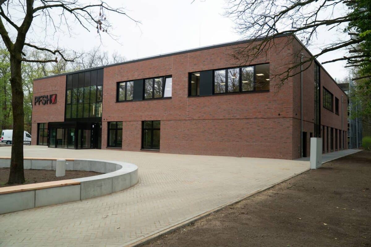 Modernes Firmengebäude der Pflegefachschule Hannover in einer grünen Umgebung.